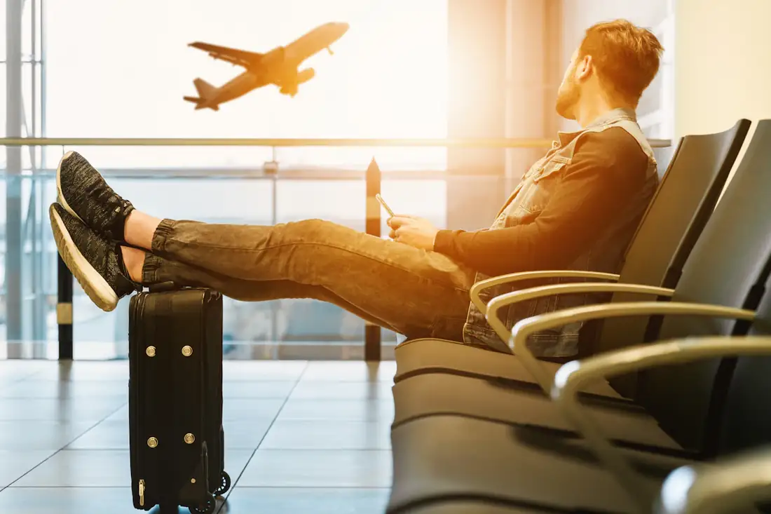 Traveller waiting at an airport as a plane takes off