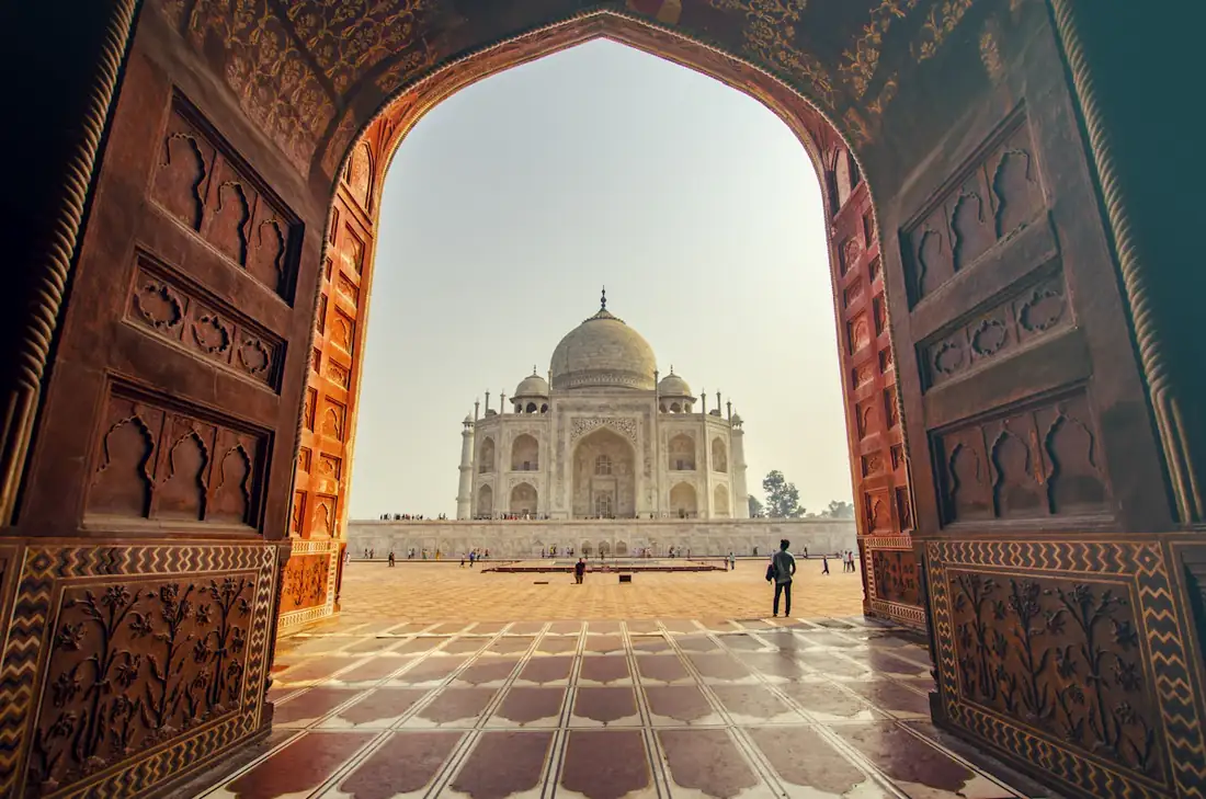 The Taj Mahal seen through a carved sandstone archway
